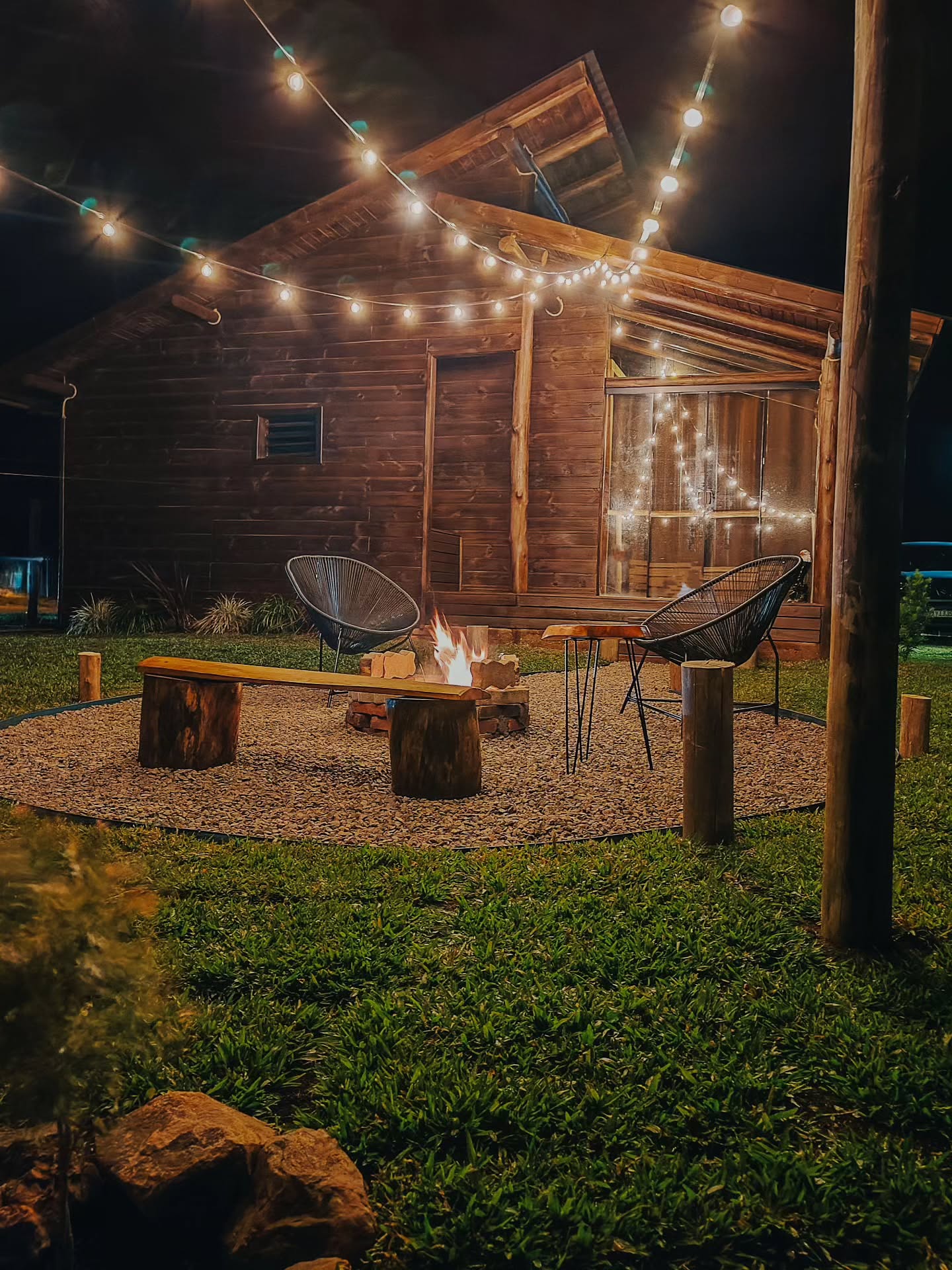 Cabana à noite com luzes e fogueira